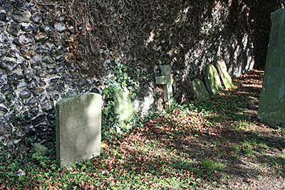Setting for headstones by flint wall - Robin Benedict Goyder infant